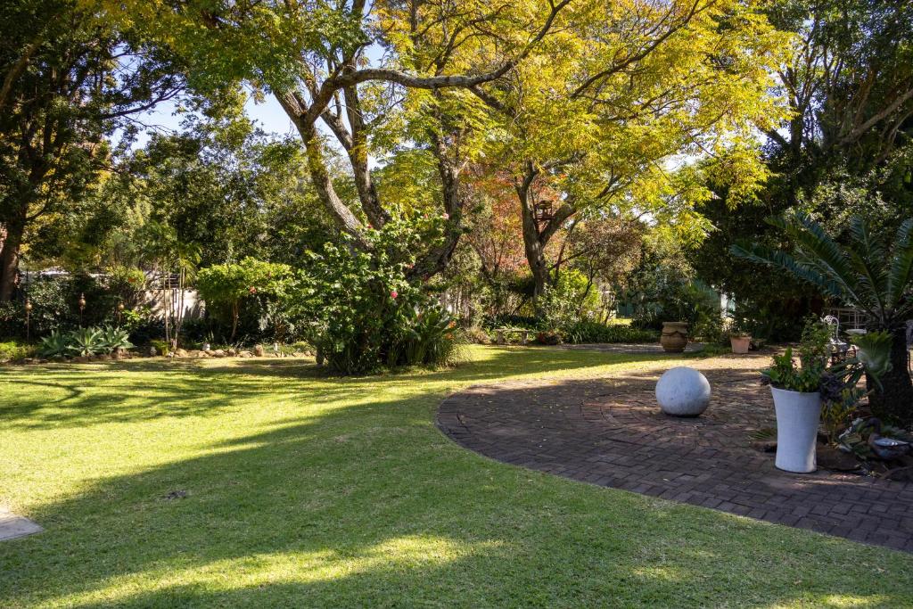 a garden with a tree and a walk way at Blessings Guesthouse in Newcastle