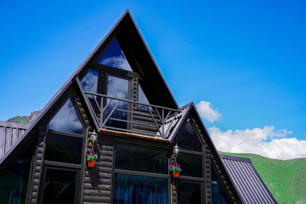 a house with a gambrel roof with windows at Kokhta Cottage Kazbegi 2 in Kazbegi