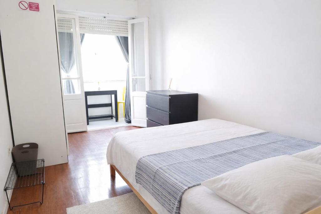 a white bedroom with a bed and a window at Colombo Mall Room in Lisbon