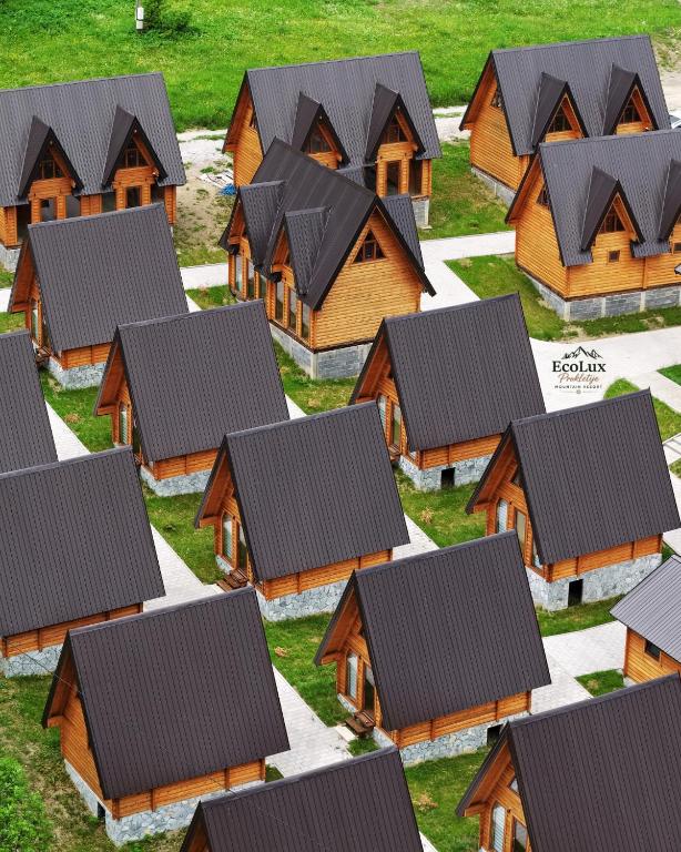 a group of wooden houses with black roofs at Eco Lux Prokletije resort in Gusinje