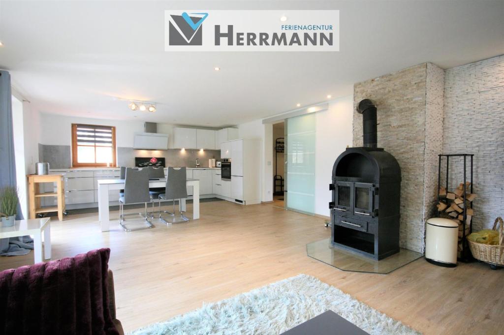 a living room with a fireplace and a kitchen at Ferienwohnung Am Mühlbach 1 in Halblech