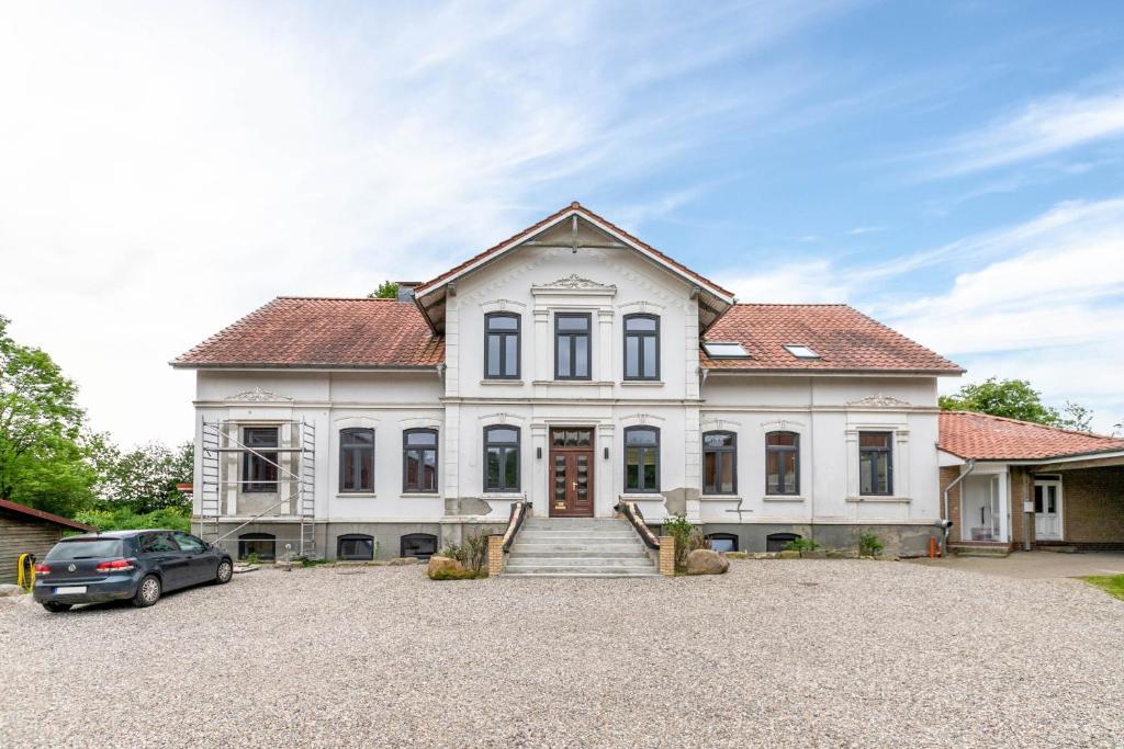 a house with a car parked in front of it at Ferienwohnung auf Dreiseithof in Twedt