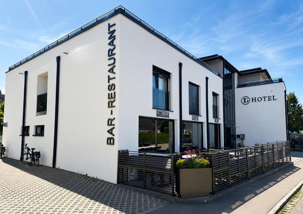 a white building with a sign on the side of it at JG Hotel & Restaurant Antoniergasse in Memmingen