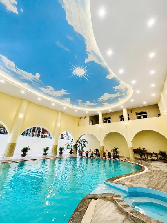 a swimming pool in a building with a ceiling filled with water at Quê Tôi Hotel in Soc Trang