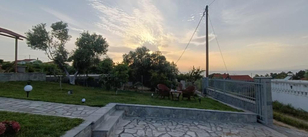 a backyard with a table and chairs on the grass at blue caravan in Nea Potidaea