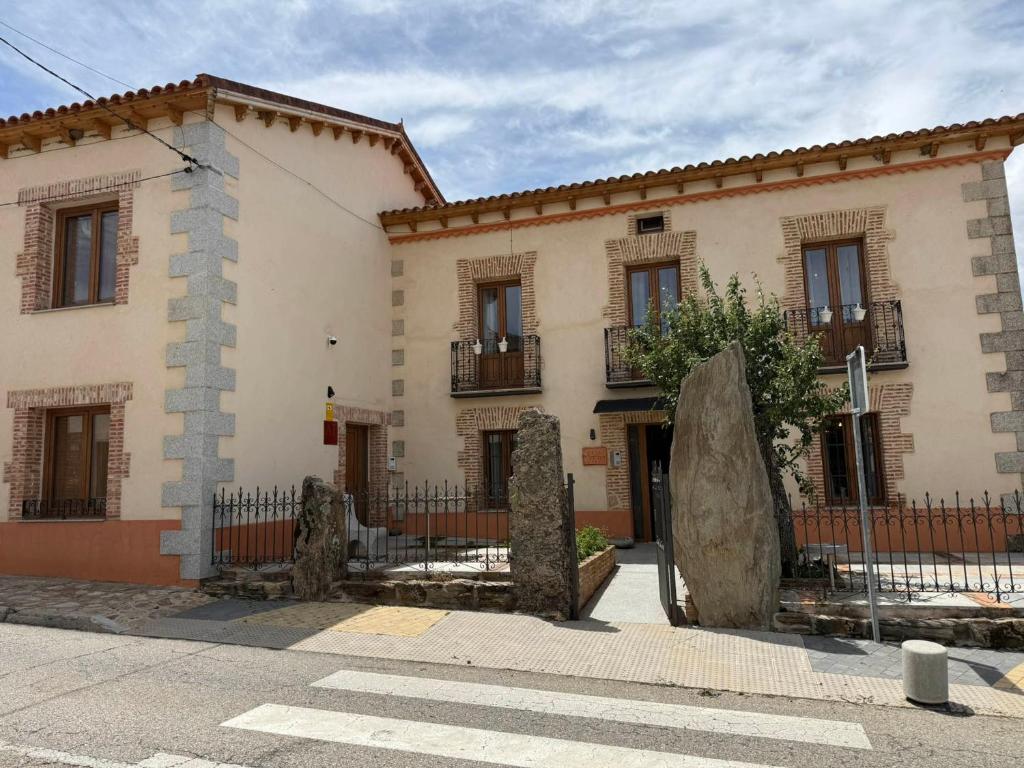 a large white building with windows and a fence at El Bulín de Prádena - Calle Real in Prádena del Rincón