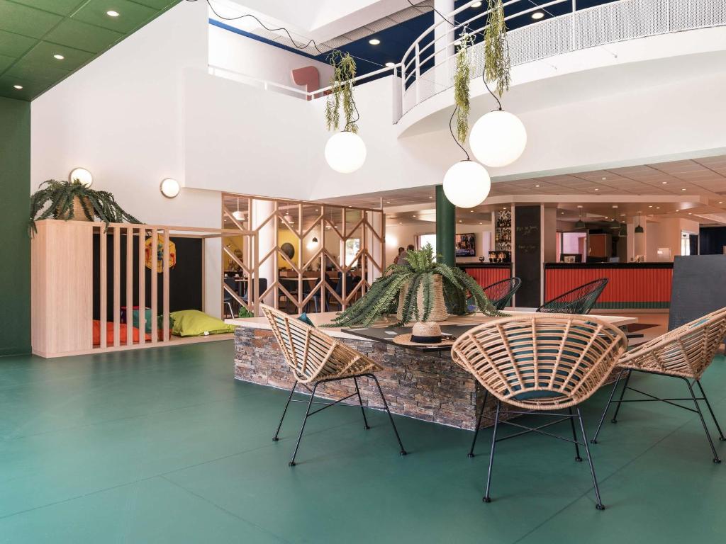 a dining room with chairs and a table in a building at ibis Styles Marseille Plan de Campagne in Les-Pennes-Mirabeau