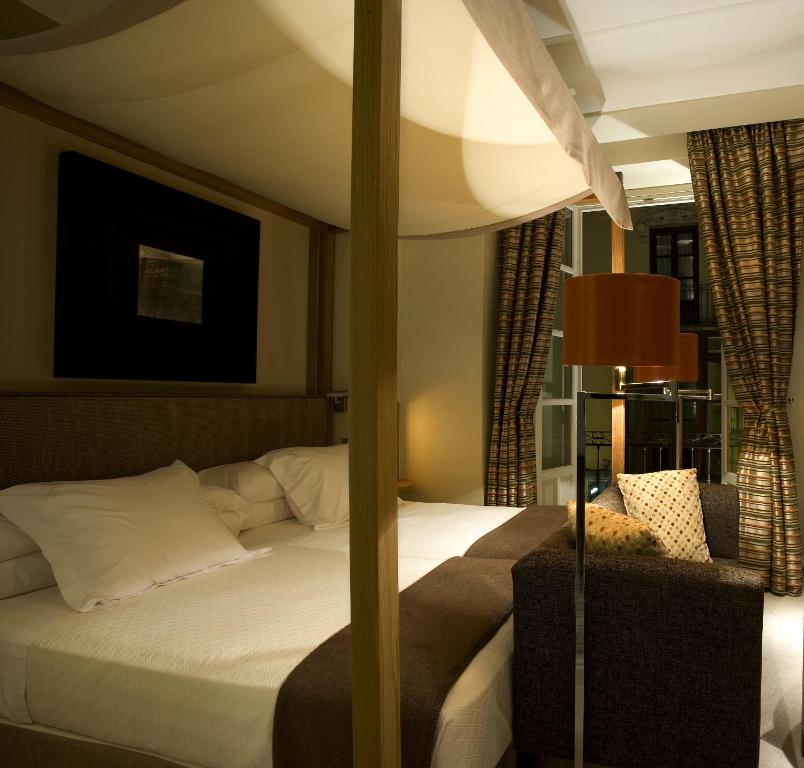 a bedroom with a bed and a lamp and curtains at Villa Oniria in Granada
