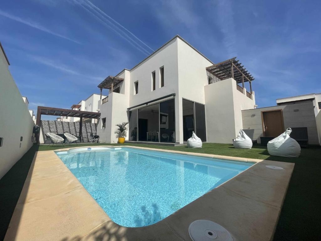 a villa with a swimming pool in front of a house at HOLYHOME VILLA CINEMA PERFECT FOR FAMILIES in Costa Teguise