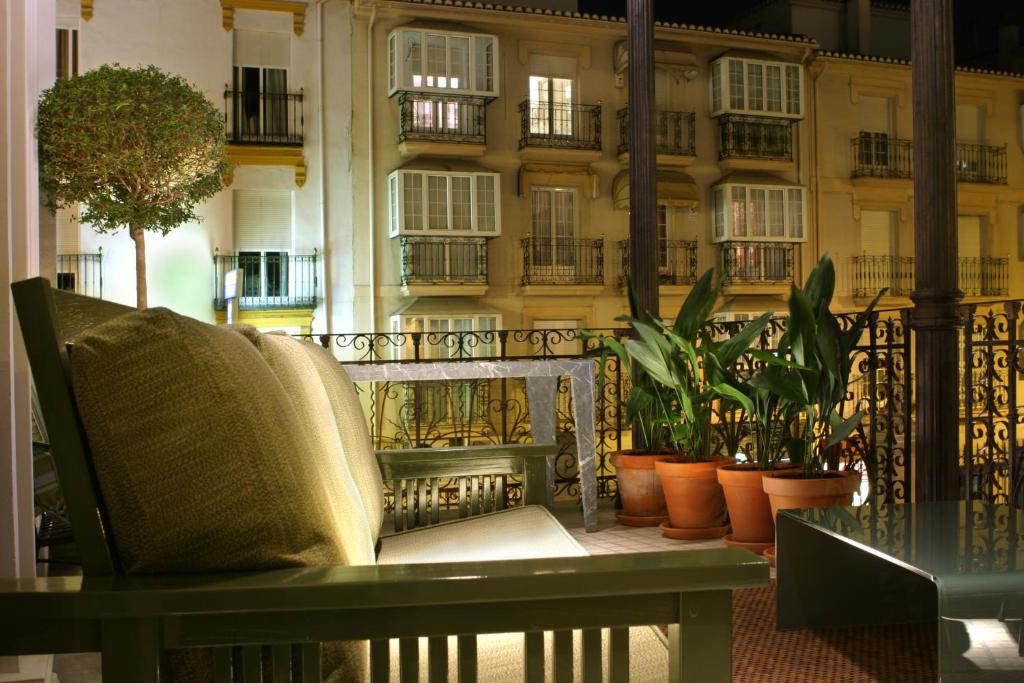 a chair on a balcony with plants and a building at Villa Oniria in Granada