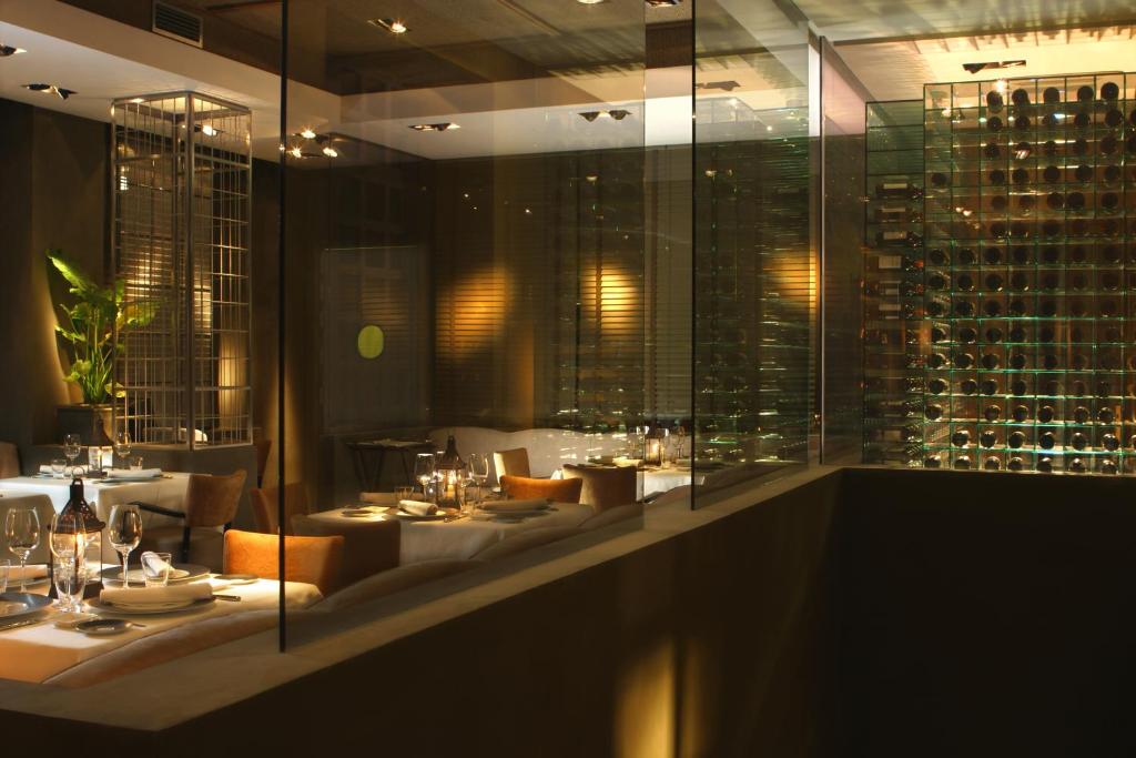 a restaurant with tables and chairs and wine bottles at Villa Oniria in Granada