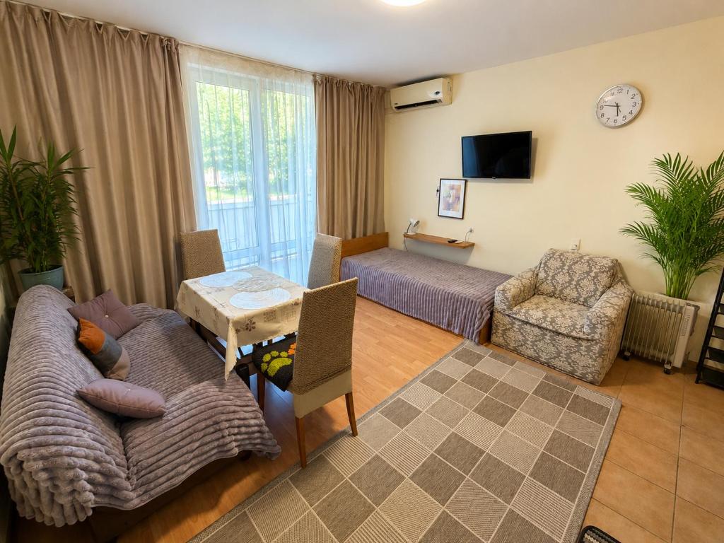 a living room with a couch and a table at Two-bedroom apartment with garden view in Sunny Beach