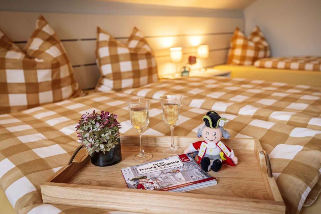 a bedroom with a bed with a table with wine glasses at Maisionette FEWO Sternchen in Heidenau