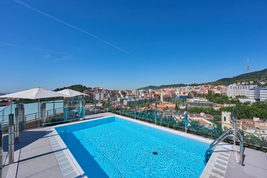 a swimming pool on the roof of a building with a view at Catalonia Park Güell in Barcelona