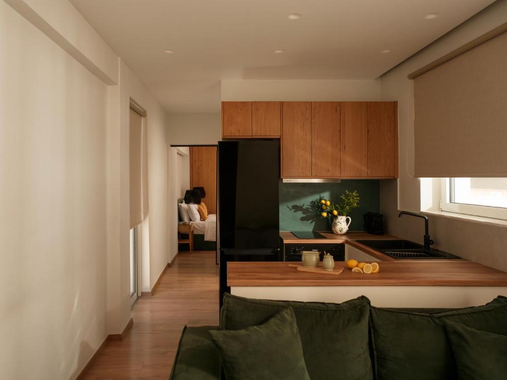 a kitchen with a couch and a black refrigerator at Eudaimonia - Luxury Apartment in Agrinio in Agrinio