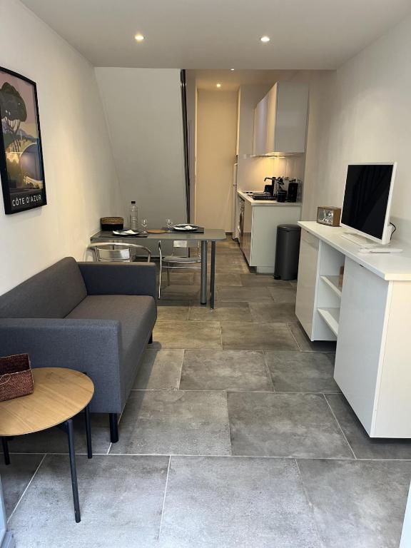 a living room with a couch and a kitchen at Splendide duplex en plein coeur de Vernon in Vernon