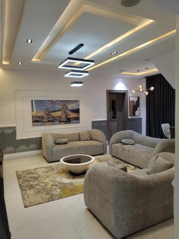 a living room with two couches and a table at 5 bedroom apartment Magodo GRA in Sagisa