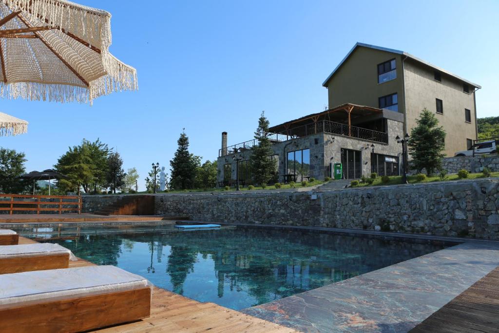 a swimming pool in front of a building at Lala Resort in Kolgecaj