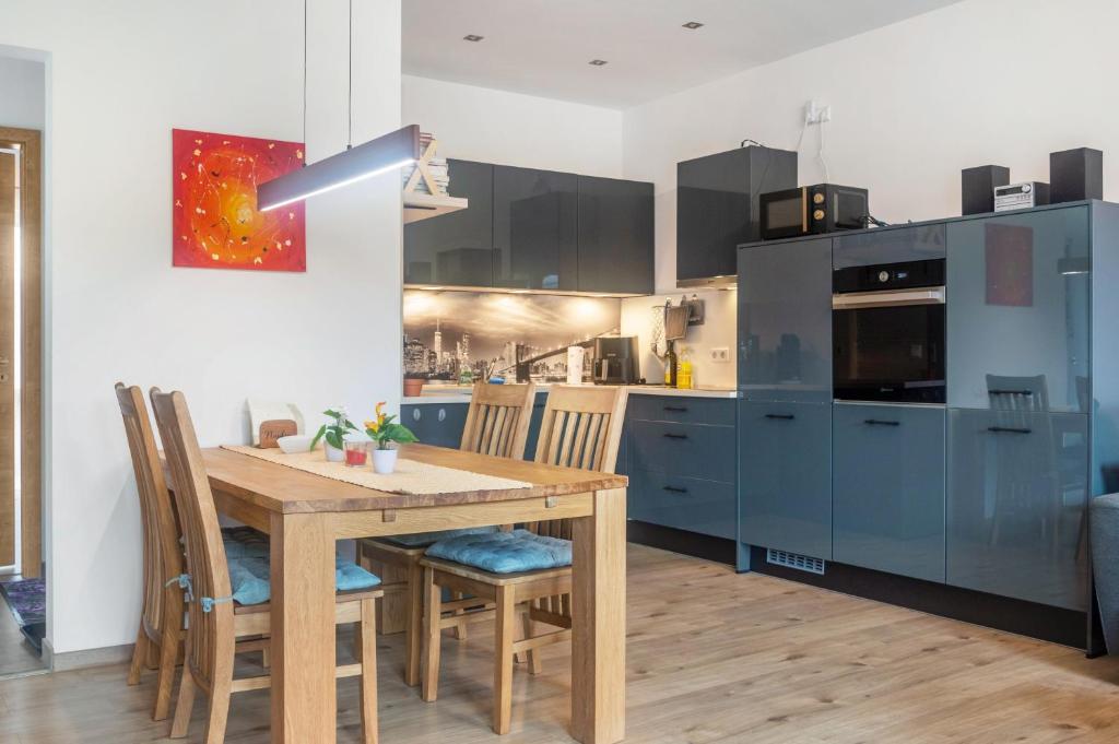 a kitchen with a wooden table and blue cabinets at Fewo im Fränkischen Seenland in Abenberg