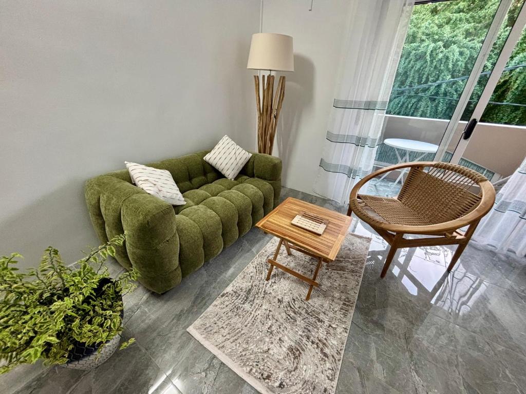a living room with a green couch and a table at Serenity villa in Pointe aux Biches