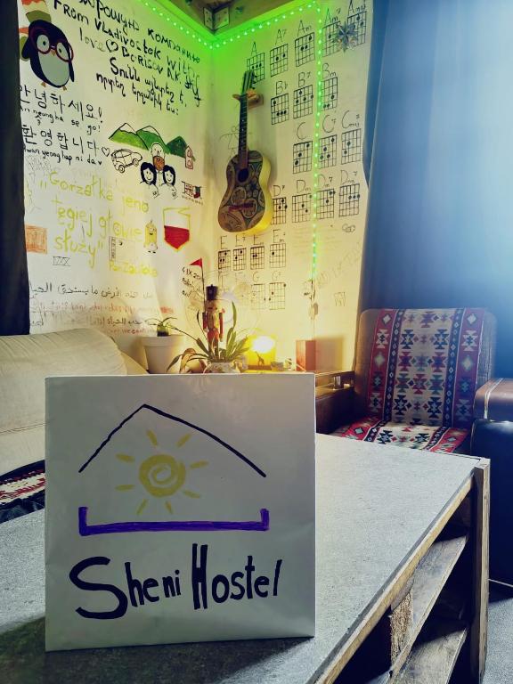 a sign on a table in a room with writing on the wall at Sheni Hostel in Tbilisi City
