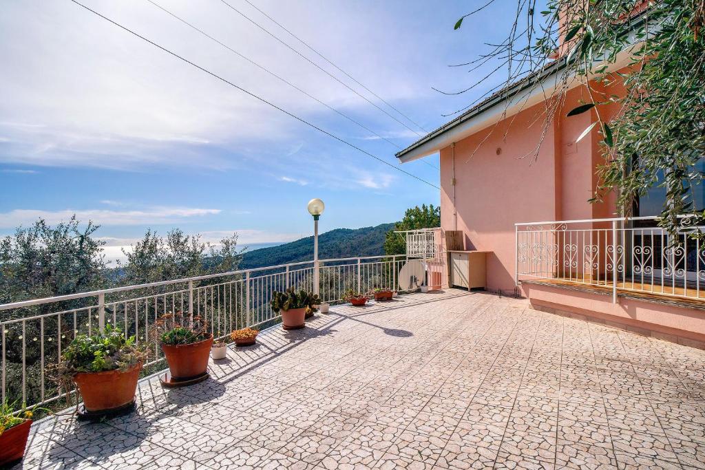a balcony of a pink building with potted plants at Paola in Villa Faraldi