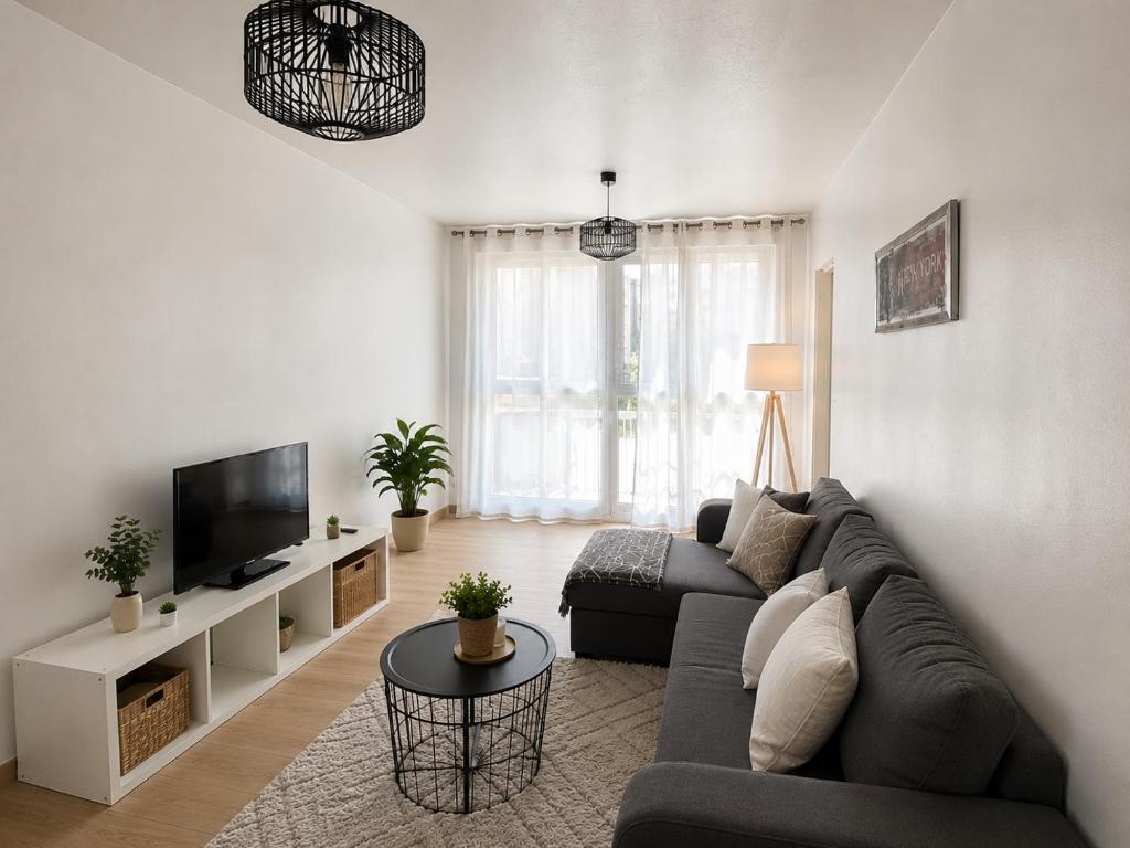 a living room with a couch and a tv at Le Cosy Thiers in Dunkerque