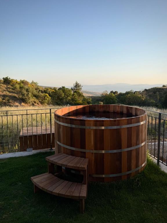 a wooden barrel sitting next to a bench at Calma Hermon Guest Rooms in Neve Ativ
