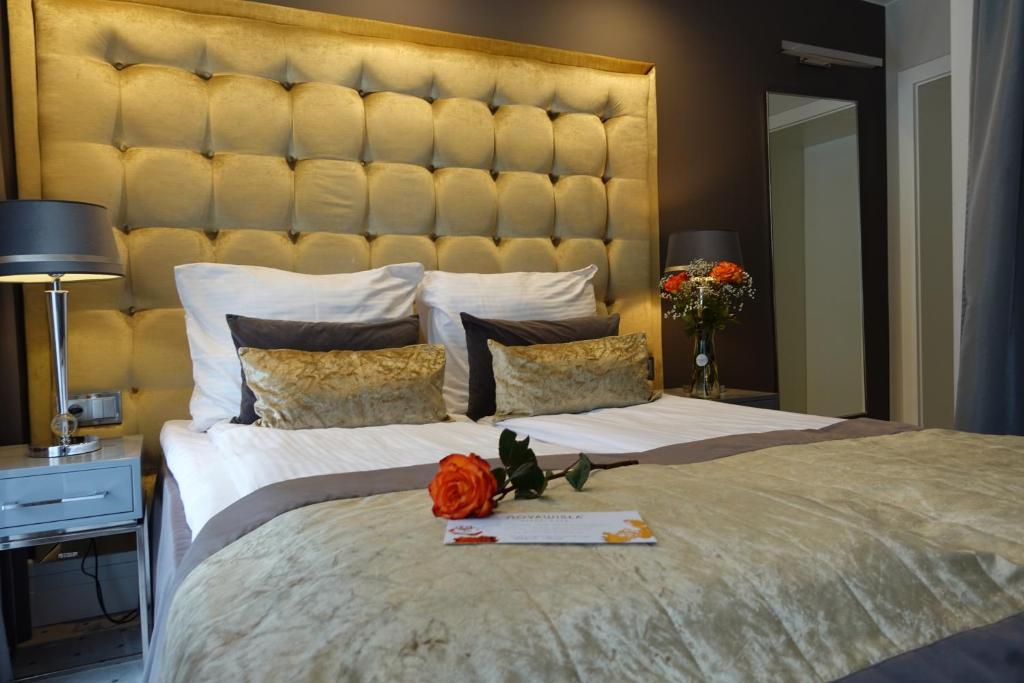 a bedroom with a large bed with a large headboard at NovaWisła Resort & SPA in Wisła