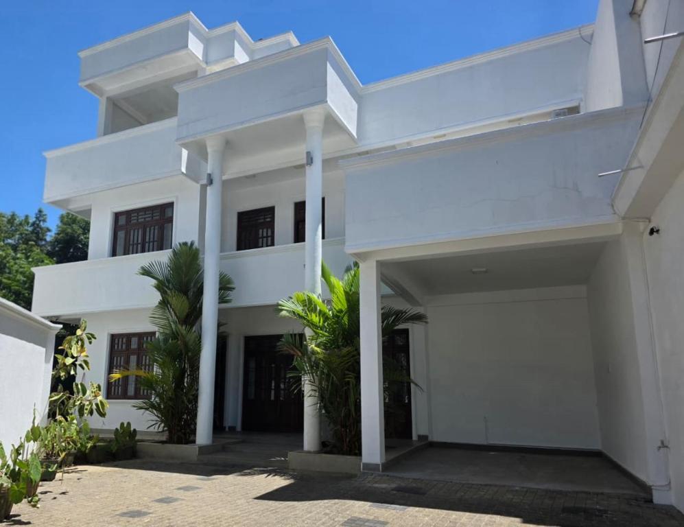a white villa with a large driveway at Villa at 37 in Badulla