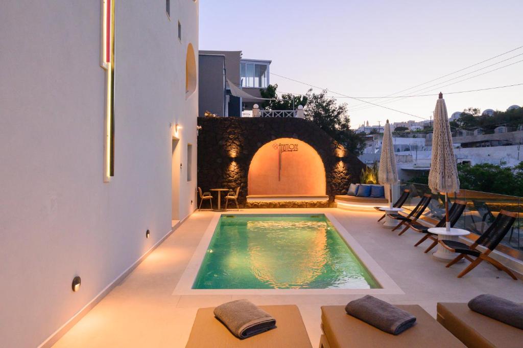 a swimming pool in the middle of a building at Anemone Luxury Suites in Fira