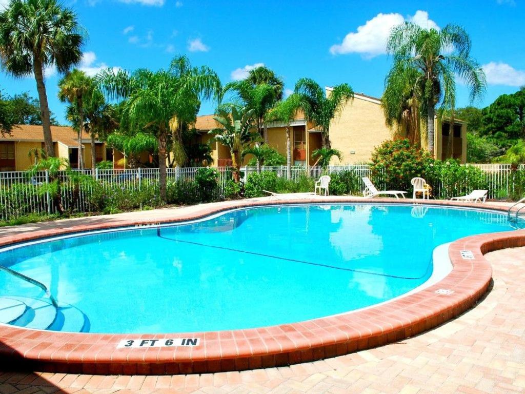 a large swimming pool with a brick path around it at 2BR/1BA Sienna Park Apartment in Sarasota