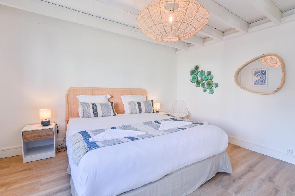 a bedroom with a large bed and a lamp at La Cabane chic des Embruns in Cabourg