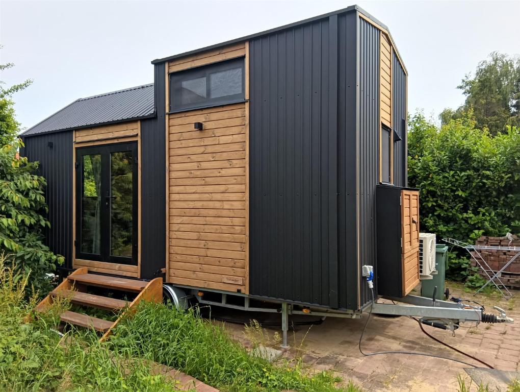 a black tiny house with a wooden exterior at Accommodatie Spiegelwaal Nijmegen Lent in Nijmegen