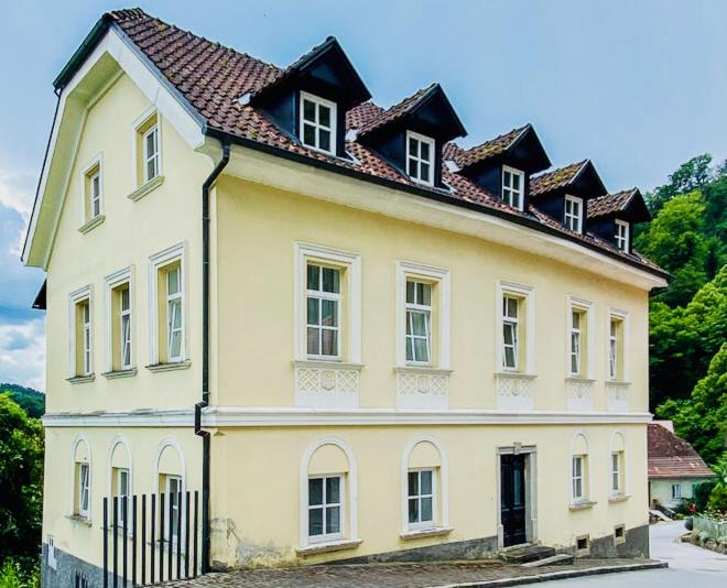 a large yellow house with a roof at Vila Kralj in Podčetrtek