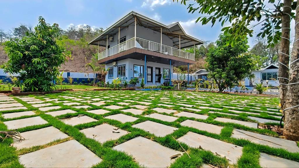 a house with a large lawn in front of it at Appa Hillside Nature Resort in Karjat