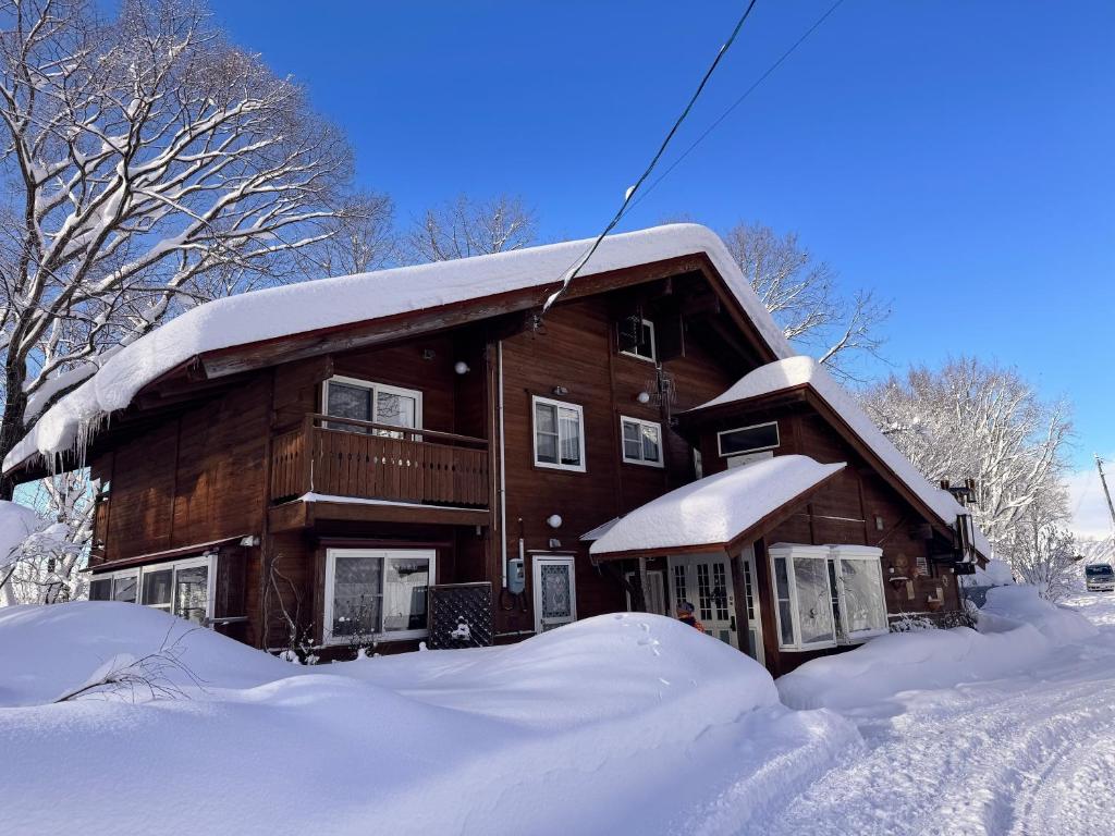 a house covered in snow with a pile of snow at Polar Bear 藏王白熊民宿 in Kaminoyama