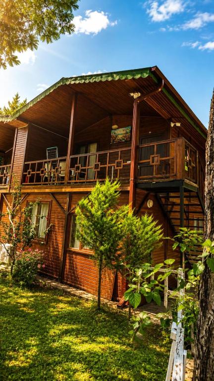 a large wooden house with a balcony on it at Cirali Camping in Cıralı