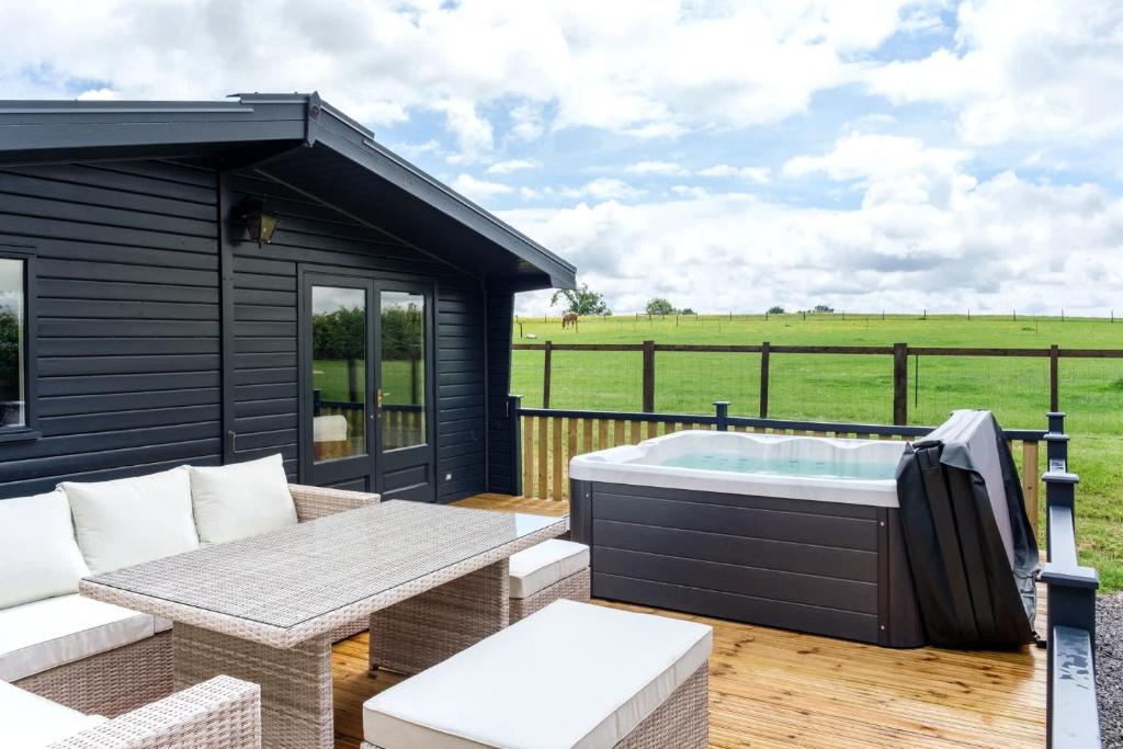 a hot tub on the deck of a tiny house at The Paddock Lodge in Withcote