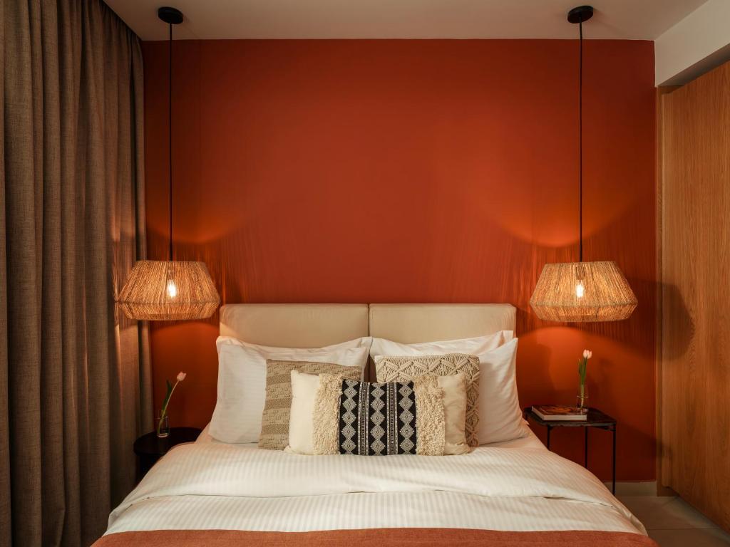 a bedroom with red walls and a bed with pillows at Deos- Luxury Apartment in Agrinio in Agrinio