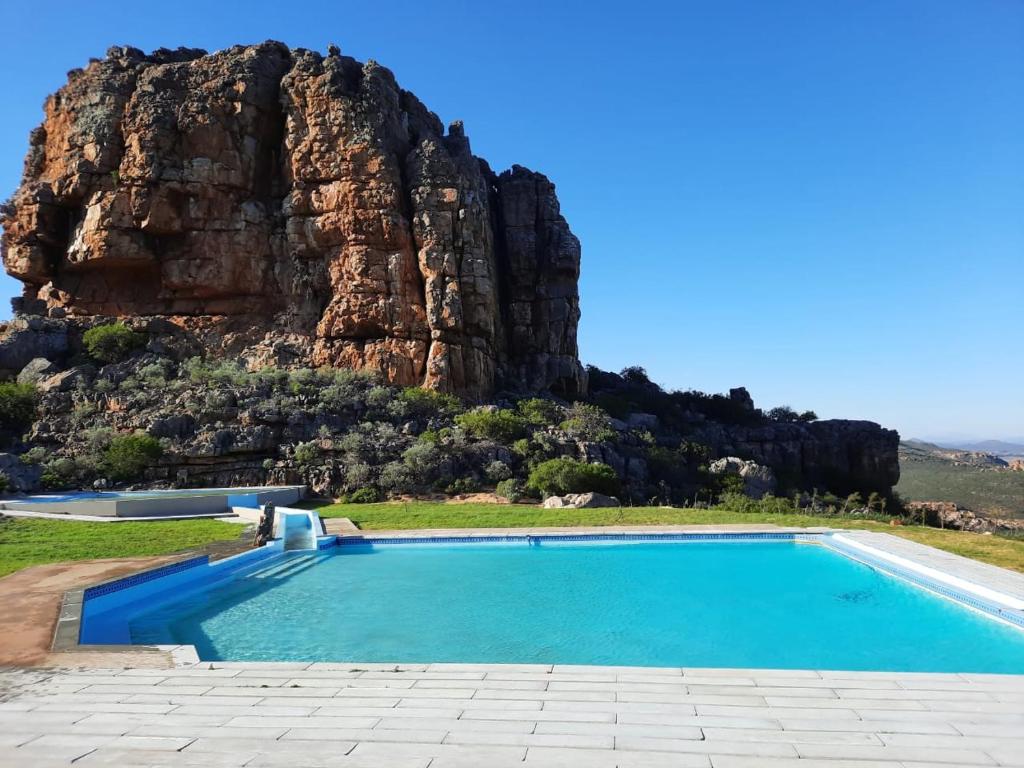 a swimming pool with a mountain in the background at Katkop Resort in Graafwater