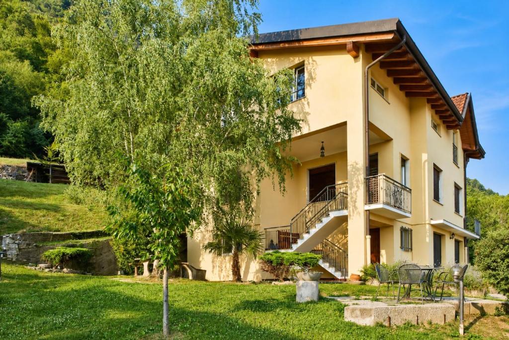 a large house with a tree in front of it at ComoVà in Maslianico