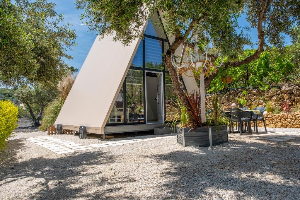 a glass house with a tree in front of it at Danae's A-Frame Nest in Daratso