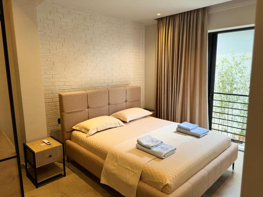a bedroom with a bed and a large window at Ritson Hotel in Vlorë