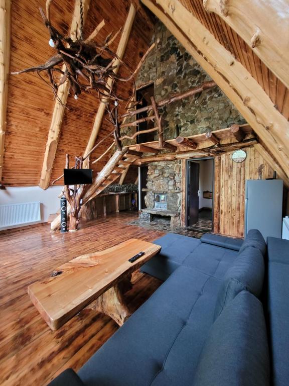 a living room with a blue couch and a wooden table at Cabana Noah Rustic in Vîlcăneşti