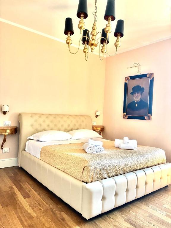 a bedroom with a large bed with a chandelier at Boutique Hotel L'Imperatrice -Vicinissimi a Valdichiana Designer Village- in Foiano della Chiana
