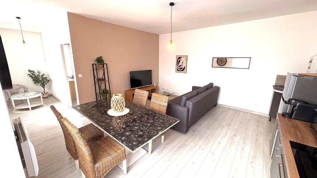 a living room with a table and a couch at La Halte Montbrisonnaise in Montbrison