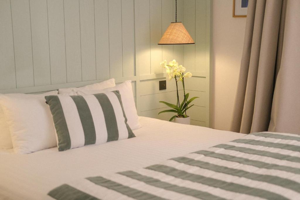 a bedroom with a bed with white pillows and a plant at Boutique Hôtel Le Clos Huguerie - Bordeaux Centre in Bordeaux