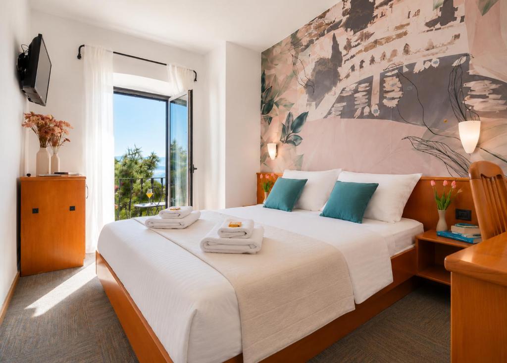 a bedroom with a large bed with towels on it at Hotel Kastil in Bol