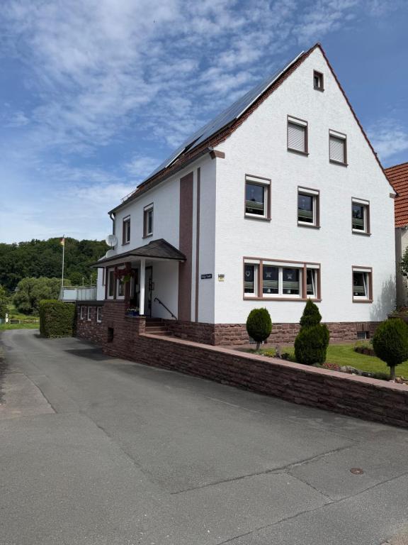 a large white house with a brick foundation at Roxy in Beverungen